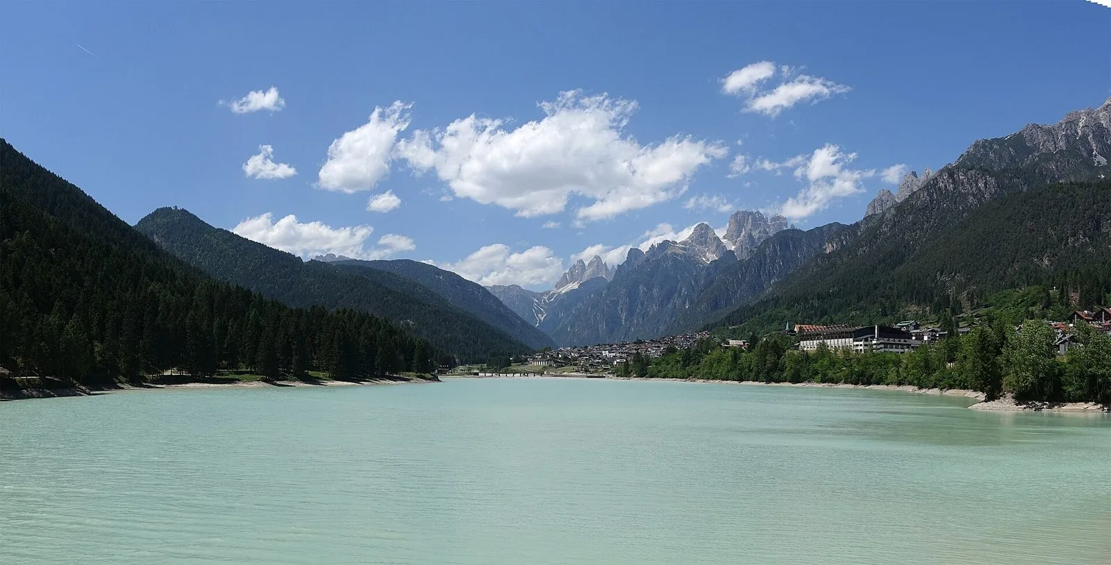 Il lago di Santa Caterina ad Auronzo di Cadore in una giornata d'estate, con il paese sulla riva destra e le guglie dolomitiche sullo sfondo